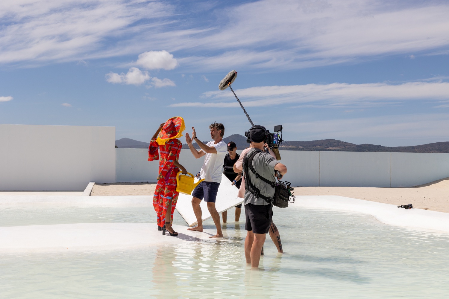 Photographer directing a model on a film set with camera crew